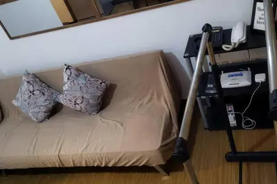 a couch with two pillows on it in a room at Cozy 1BR-Grace Residences in Manila