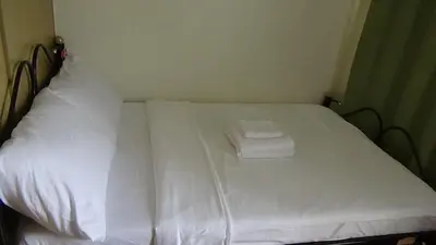 a bed with white sheets and two towels on it at Cozy 1BR-Grace Residences in Manila
