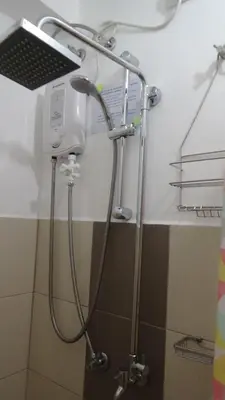 a shower with a shower head in a bathroom at Cozy 1BR-Grace Residences in Manila