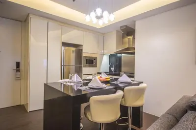a kitchen with a black table and chairs at The Alpha Suites in Manila