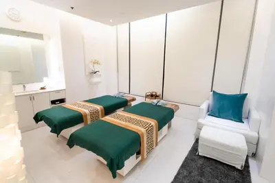 a room with three beds and a chair at The Alpha Suites in Manila