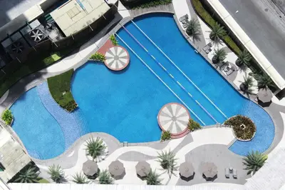 an overhead view of a swimming pool with palm trees at The Alpha Suites in Manila