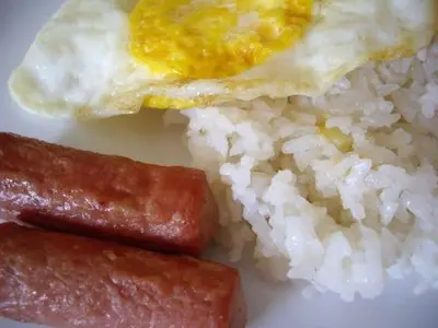 a plate of rice and an egg and sausage at Lourdes Inn in Manila