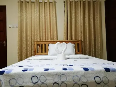 a bedroom with a bed with two white towels at Lourdes Inn in Manila