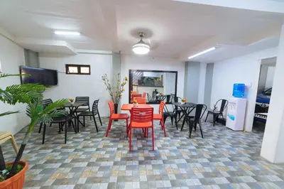 a dining room with red chairs and a table at RedDoorz at San Antonio Binan Laguna in Biñan