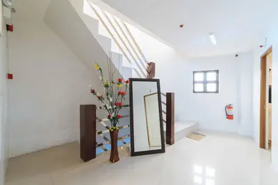a mirror and a vase with flowers in a room at RedDoorz at San Antonio Binan Laguna in Biñan