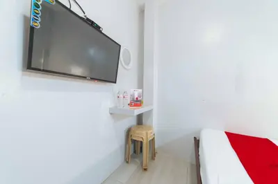 a bedroom with a bed and a tv on a wall at RedDoorz at San Antonio Binan Laguna in Biñan