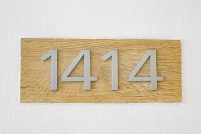 a wooden sign with the number four forty four at Titan Condo at Studio City Tower 3 Alabang in Manila
