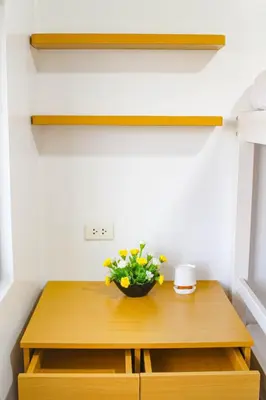 a small wooden table with a bowl of flowers on it at Titan Condo at Studio City Tower 3 Alabang in Manila