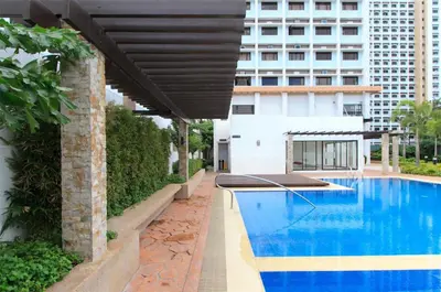 a large blue swimming pool with a large building at Titan Condo at Studio City Tower 3 Alabang in Manila