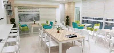 a dining room with white tables and chairs at Titan 22P Condo at WH Taft Residences Manila in Manila