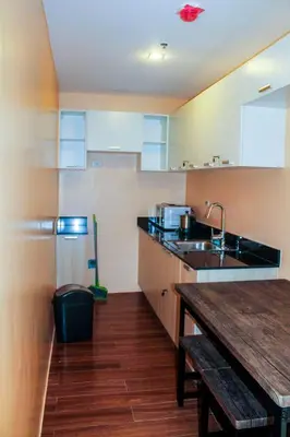a kitchen with a sink and a wooden table at Titan 22P Condo at WH Taft Residences Manila in Manila