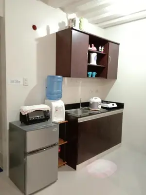 a small kitchen with a sink and a counter at Jen's Paranaque City Apartment in Manila