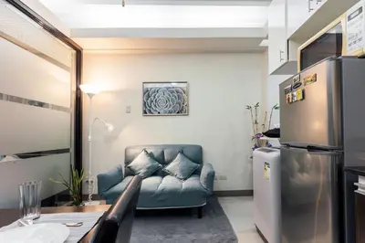a living room with a couch and a refrigerator at Jen's Paranaque City Apartment in Manila