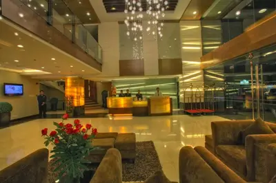 a lobby with couches and flowers in a building at Armada Hotel Manila in Manila