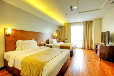 a hotel room with two beds and a television at Armada Hotel Manila in Manila