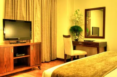a hotel room with a bed and a television and a desk at Armada Hotel Manila in Manila