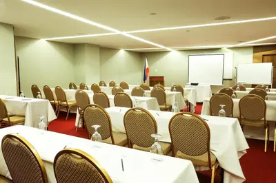 a conference room with tables and chairs and a screen at Armada Hotel Manila in Manila