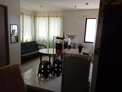 a living room with a table and a couch at Spacious Studio unit beside Enchanted Kingdom at Santa Rosa City Laguna in Santa Rosa