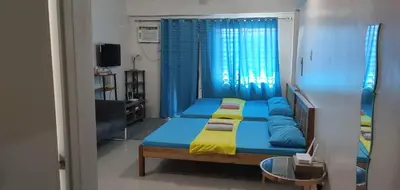 a bedroom with two beds with blue and yellow sheets at Vimelzu Mhavic Family Room in Manila