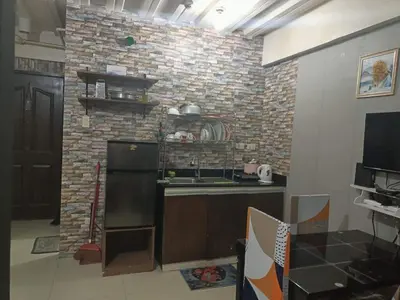 a kitchen with a brick wall and a black refrigerator at Vimelzu Mhavic Family Room in Manila