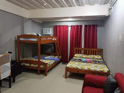 a bedroom with two bunk beds and a couch at Vimelzu Mhavic Family Room in Manila