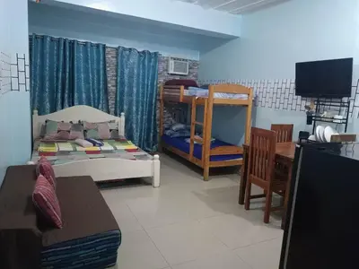 a room with two bunk beds and a table at Vimelzu Mhavic Family Room in Manila