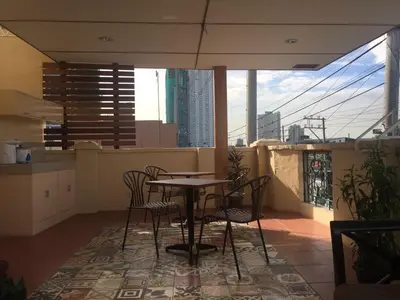 a table and chairs on a balcony with a view at 1 River Central Hostel in Manila