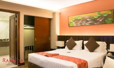 a bedroom with a large bed in a room at Ramada by Wyndham Manila Central in Manila