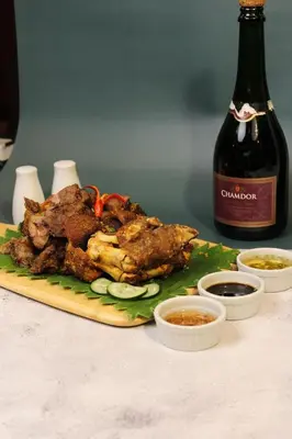 a plate of food on a table with a bottle of wine at Ramada by Wyndham Manila Central in Manila