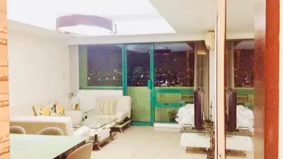 a living room with a view of a city at 67 sqm. Condo Unit in Robinson Place Residences in Manila