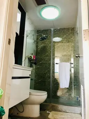 a bathroom with a toilet and a glass shower at 67 sqm. Condo Unit in Robinson Place Residences in Manila