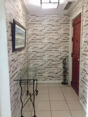 a stone wall with a glass table in a hallway at 67 sqm. Condo Unit in Robinson Place Residences in Manila