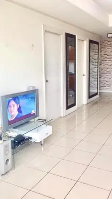 a living room with a television and a white floor at 67 sqm. Condo Unit in Robinson Place Residences in Manila