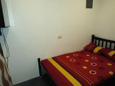 a bedroom with a bed with a red and yellow blanket at Diaz Residence in Silang