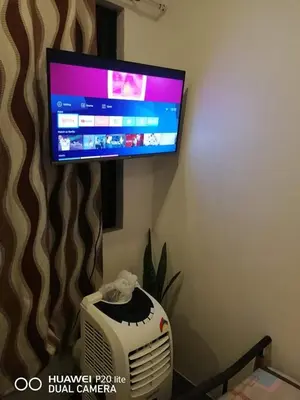 a flat screen tv hanging on a wall next to a radiator at Diaz Residence in Silang