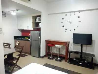 a kitchen with a refrigerator and a clock on the wall at 1BR and Studio Condo Unit @ 150 Newport near NAIA 3 in Manila