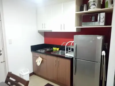 a kitchen with a stainless steel refrigerator and a sink at 1BR and Studio Condo Unit @ 150 Newport near NAIA 3 in Manila