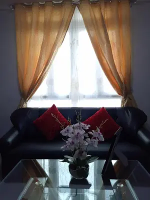 a vase of flowers on a glass table in front of a window at 1BR and Studio Condo Unit @ 150 Newport near NAIA 3 in Manila