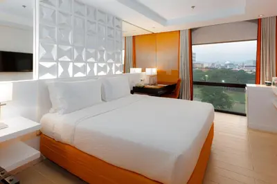 a bedroom with a large bed and a large window at The Bayleaf Intramuros in Manila