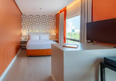 a hotel room with a bed and a desk and a tv at The Bayleaf Intramuros in Manila