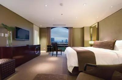 a hotel room with a bed and a large window at The Bayleaf Intramuros in Manila