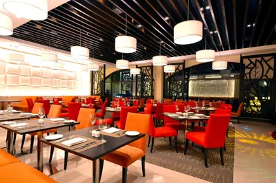 a dining room with tables and red chairs at The Bayleaf Intramuros in Manila