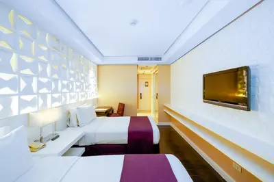 a hotel room with two beds and a flat screen tv at The Bayleaf Intramuros in Manila
