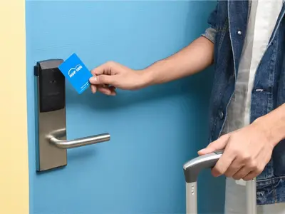 a person holding a credit card in a door handle at Hop Inn Hotel Alabang Manila in Manila