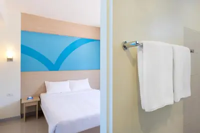 a hotel room with a bed and a towel at Hop Inn Hotel Alabang Manila in Manila