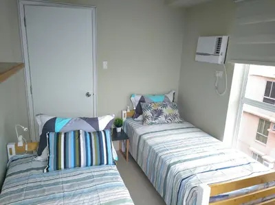 a bedroom with two beds and a window at 2BR avida tower near NAIA airport in Manila