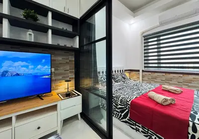 a bedroom with a large screen tv and a bed at Lotus Residence, Manila in Manila