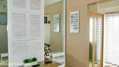 a living room with a mirror and a table at Genesis unit SMDC Fields in Manila