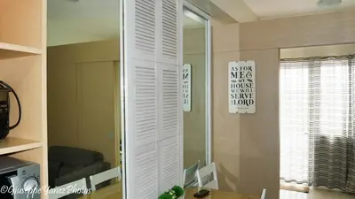 a mirror in a room with a chair and a table at Genesis unit SMDC Fields in Manila